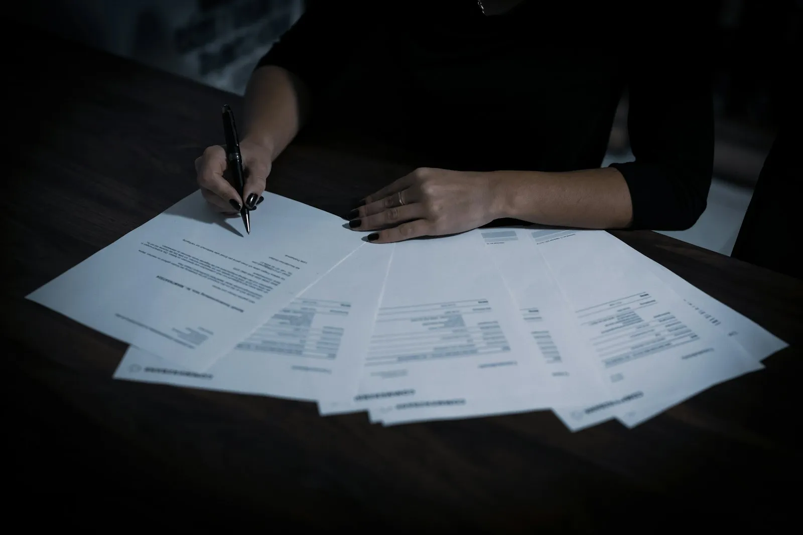 Специалист считает расходы, разложив документы на столе